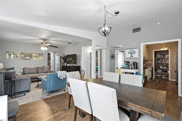 dining room with dark hardwood / wood-style floors and ceiling fan with notable chandelier