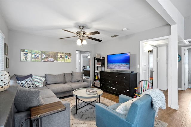 living room featuring ceiling fan, light hardwood / wood-style flooring, and a wealth of natural light