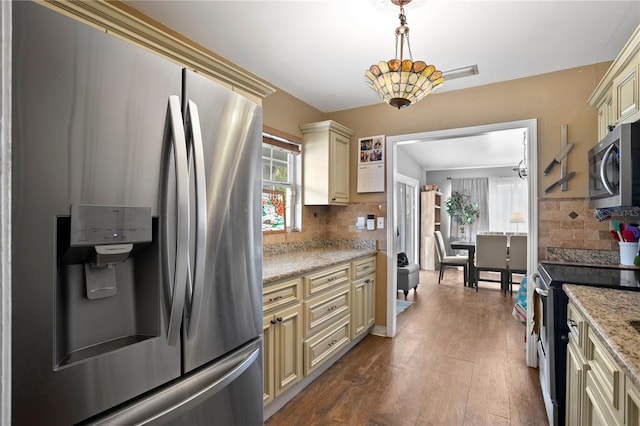 kitchen with plenty of natural light, appliances with stainless steel finishes, decorative backsplash, and cream cabinetry