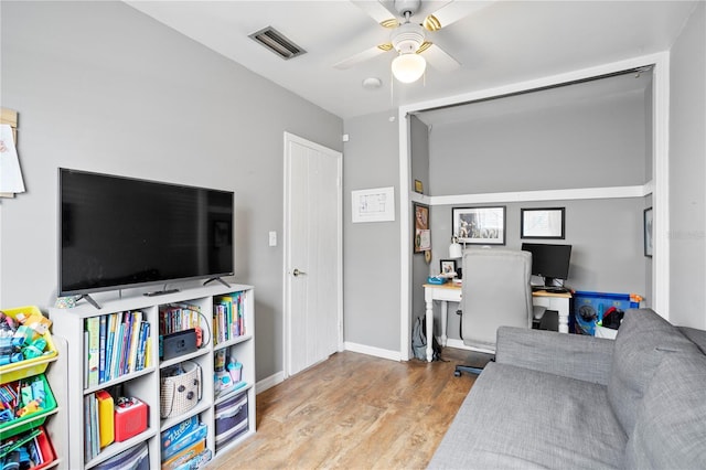 living room with wood-type flooring and ceiling fan