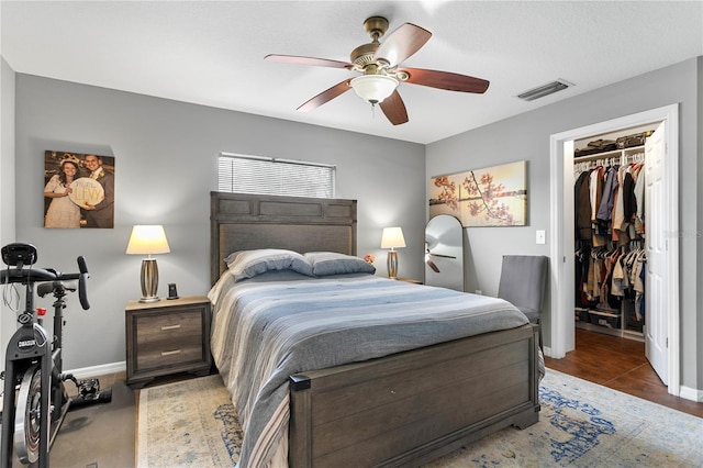 bedroom with a walk in closet, a closet, and ceiling fan