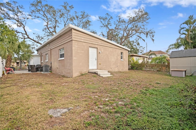 view of outbuilding featuring a yard and central AC