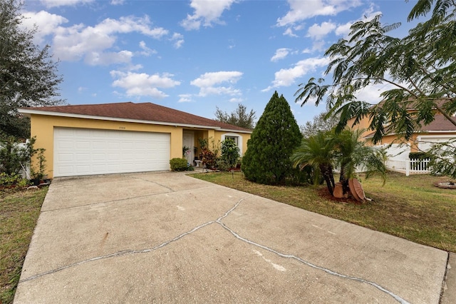 ranch-style house featuring a garage and a front lawn