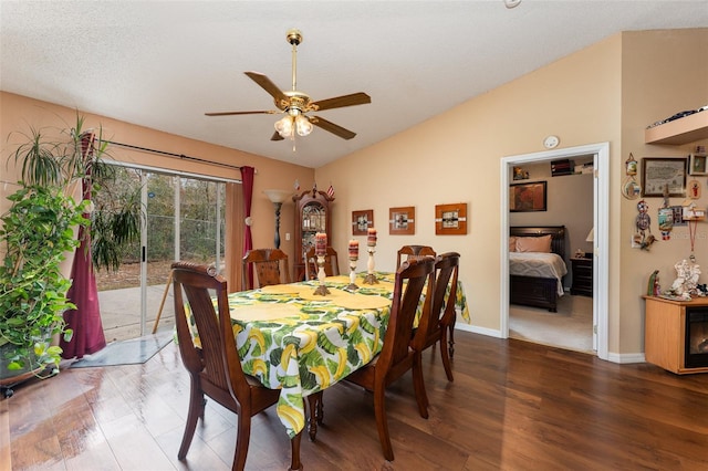 dining space featuring vaulted ceiling, dark wood-type flooring, a textured ceiling, and ceiling fan