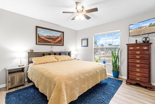 bedroom with light hardwood / wood-style floors and ceiling fan