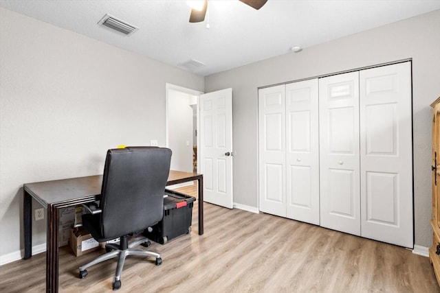 home office with light hardwood / wood-style floors and ceiling fan