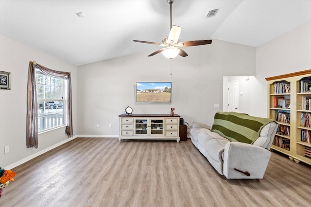 living area featuring ceiling fan, lofted ceiling, and light wood-type flooring