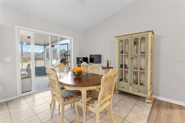 tiled dining space with vaulted ceiling