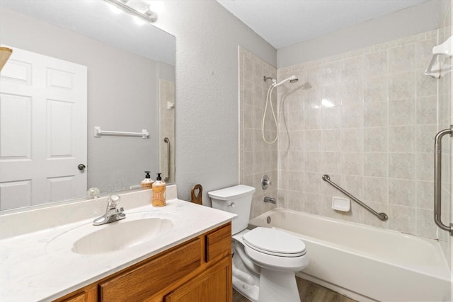 full bathroom featuring tiled shower / bath combo, vanity, hardwood / wood-style flooring, and toilet