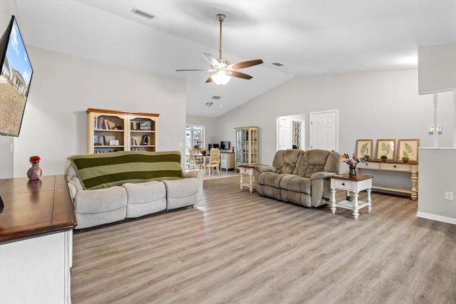 living room with lofted ceiling, ceiling fan, and light hardwood / wood-style flooring