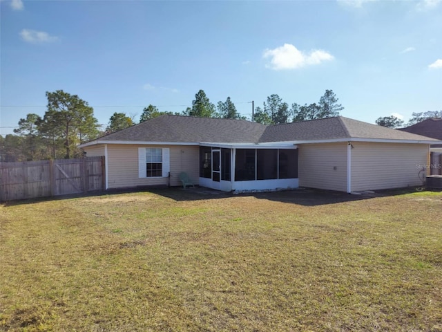 rear view of house featuring a yard, a sunroom, and central air condition unit