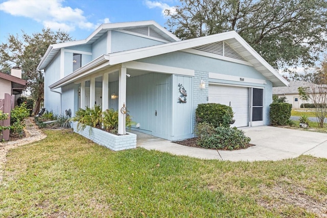 view of side of home featuring a yard, driveway, a garage, and covered porch