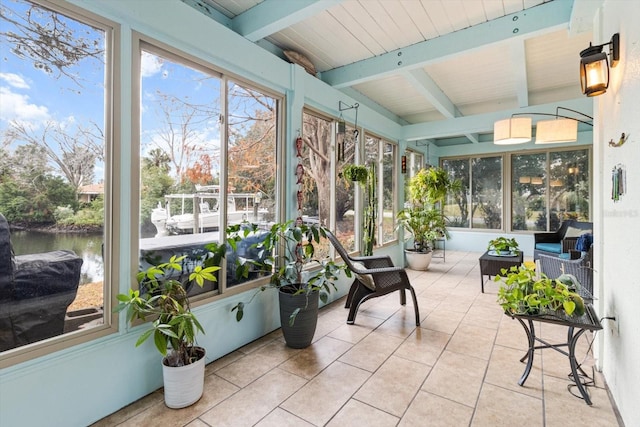 sunroom featuring beamed ceiling and a water view