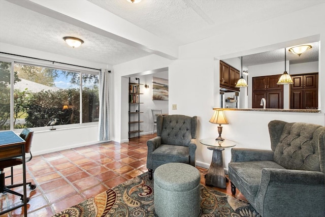 living room featuring a textured ceiling, baseboards, and tile patterned flooring