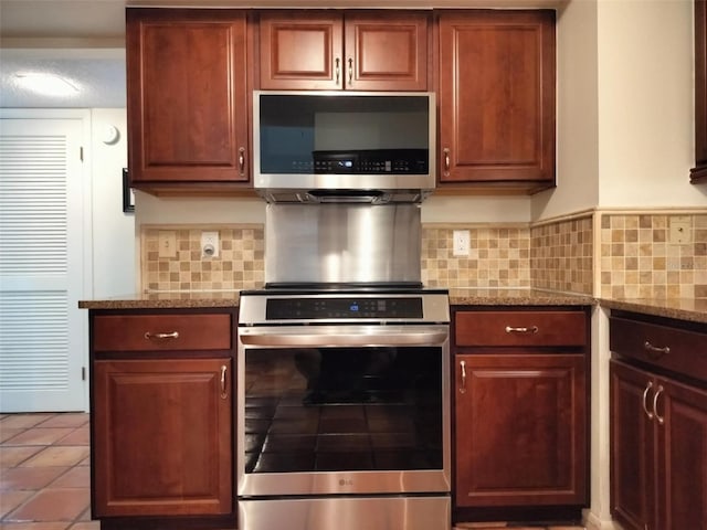 kitchen featuring appliances with stainless steel finishes, backsplash, tile patterned flooring, and light stone counters
