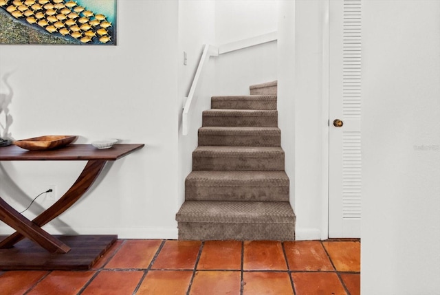 staircase featuring tile patterned floors and baseboards