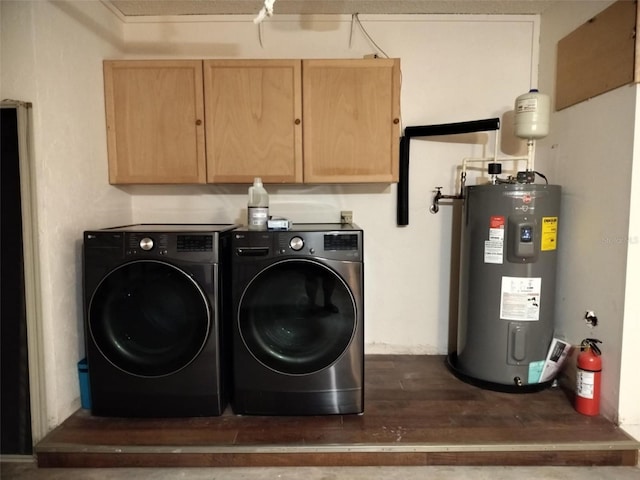 washroom featuring cabinet space, water heater, washing machine and dryer, and dark wood finished floors
