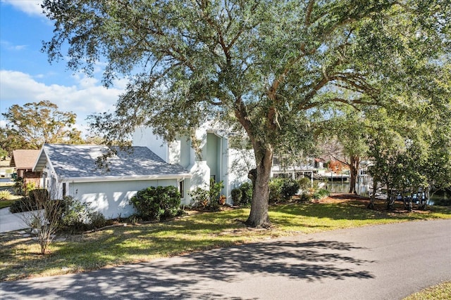 view of property hidden behind natural elements featuring a front yard