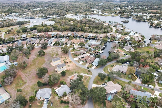 aerial view of property and surrounding area featuring nearby suburban area and a large body of water