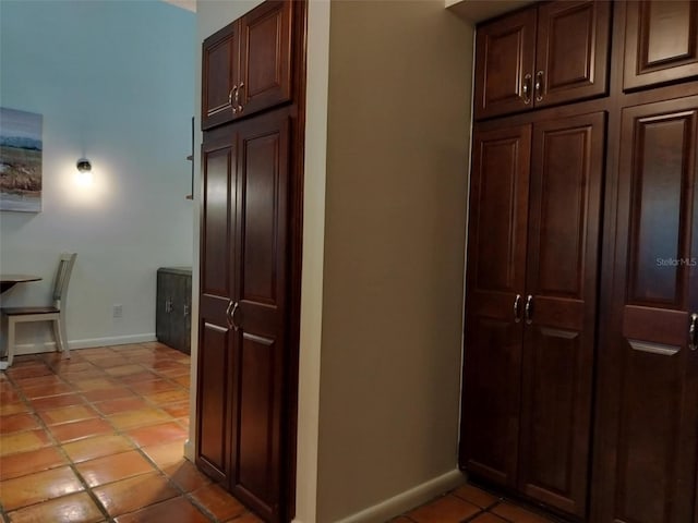 hallway featuring light tile patterned floors and baseboards