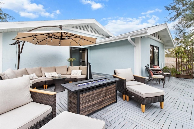 wooden deck featuring an outdoor living space with a fire pit