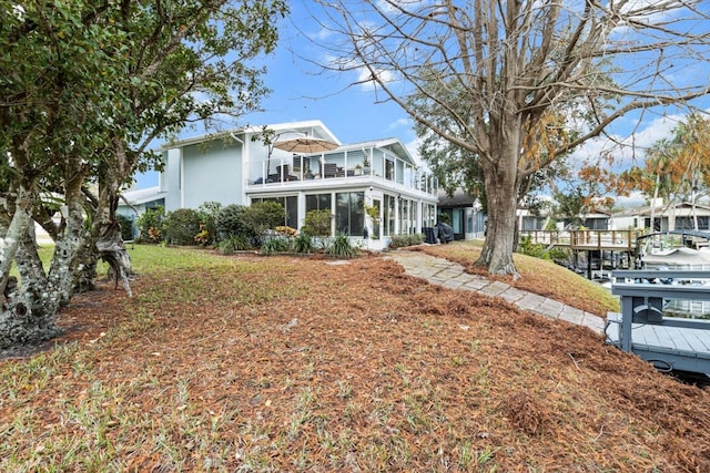 back of property featuring a balcony, stucco siding, and a sunroom