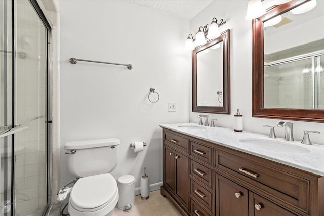 bathroom featuring tile patterned floors, toilet, double vanity, a tile shower, and a textured ceiling
