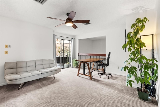 living area with carpet flooring, a ceiling fan, baseboards, and a textured ceiling