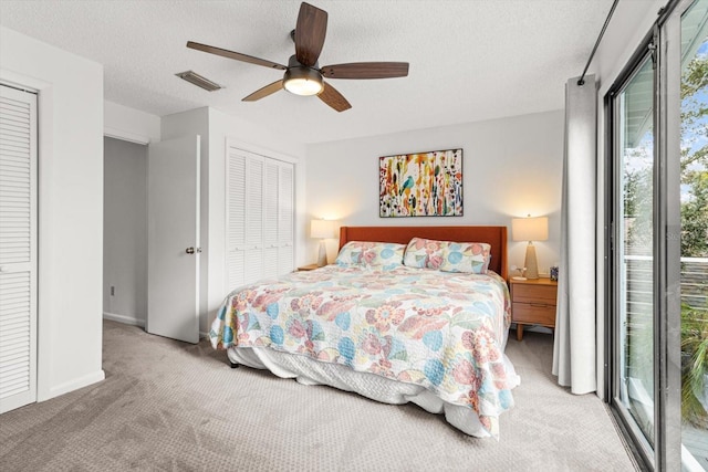 bedroom with carpet flooring, multiple closets, a textured ceiling, a ceiling fan, and baseboards