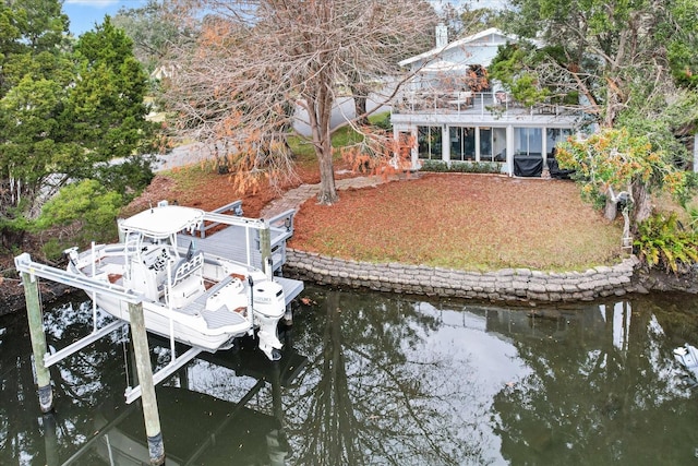 dock featuring boat lift, a balcony, and a water view