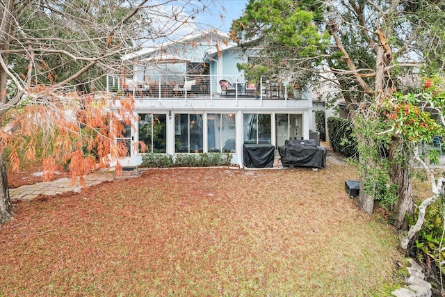 rear view of house featuring a balcony and a sunroom