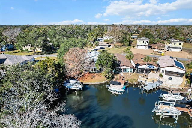 aerial perspective of suburban area featuring a nearby body of water and a tree filled landscape