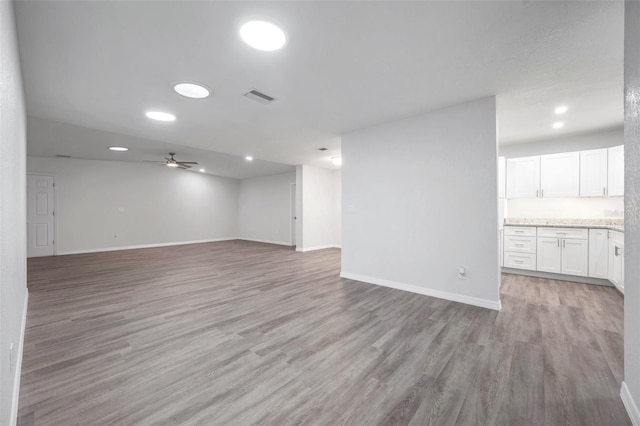 unfurnished living room featuring ceiling fan and light wood-type flooring