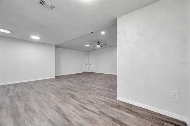 empty room featuring ceiling fan, wood-type flooring, and a textured ceiling