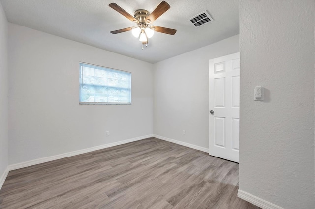 empty room featuring ceiling fan and light hardwood / wood-style floors