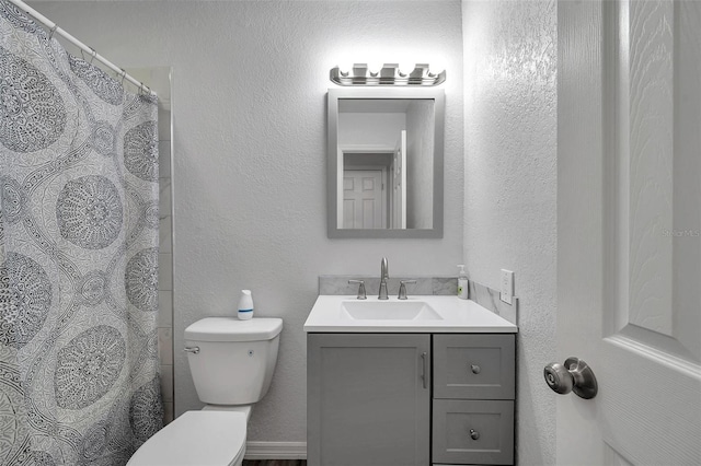 bathroom featuring vanity, curtained shower, and toilet