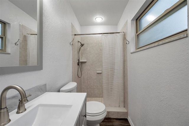 bathroom featuring hardwood / wood-style flooring, vanity, a textured ceiling, curtained shower, and toilet