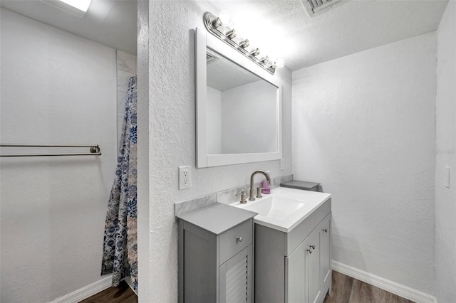 bathroom featuring wood-type flooring, a textured ceiling, and vanity