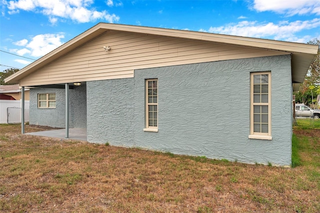 view of home's exterior featuring a patio area and a lawn