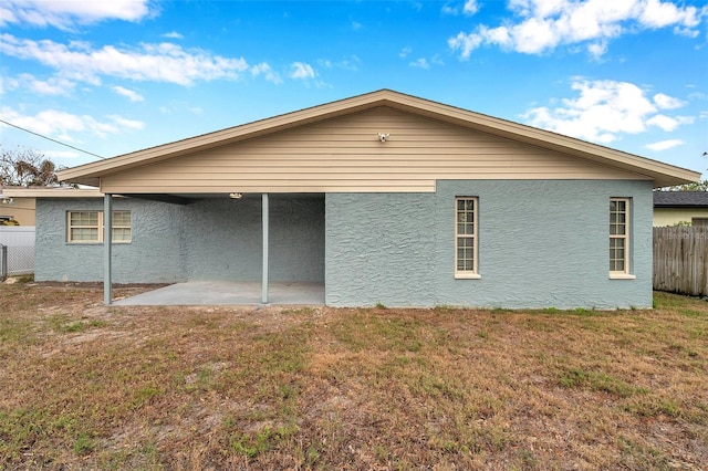 rear view of property featuring a yard and a patio