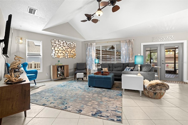 tiled living room with ceiling fan, a textured ceiling, and lofted ceiling