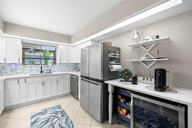 kitchen with sink, stainless steel appliances, white cabinetry, and wine cooler