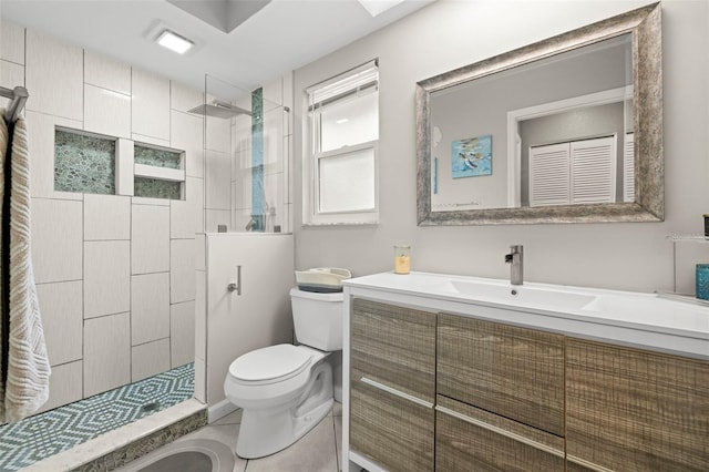 bathroom with vanity, toilet, and a tile shower