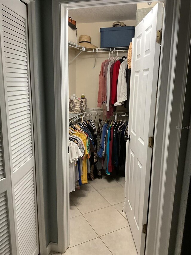 walk in closet featuring light tile patterned flooring