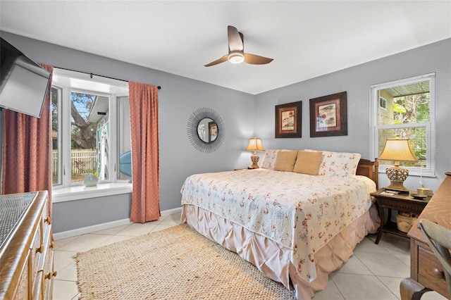 tiled bedroom featuring multiple windows and ceiling fan