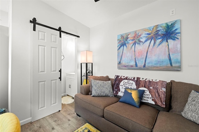 living room with a barn door and light hardwood / wood-style floors