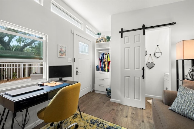 office with hardwood / wood-style flooring and a barn door