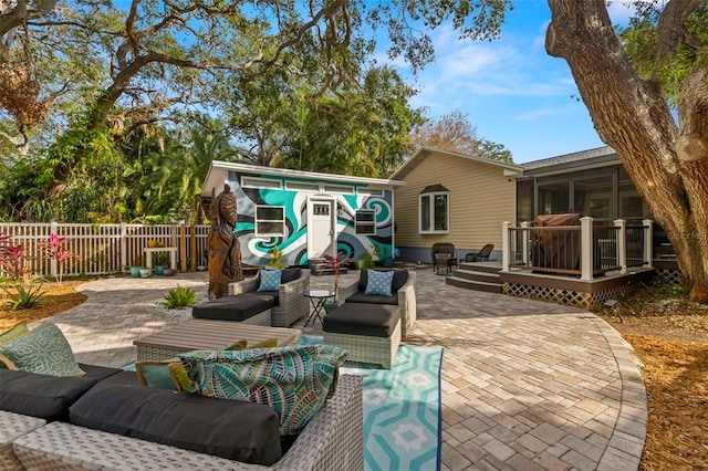 view of patio featuring a wooden deck, an outdoor hangout area, and a sunroom