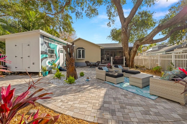 view of patio / terrace featuring a sunroom, an outdoor hangout area, and a storage unit