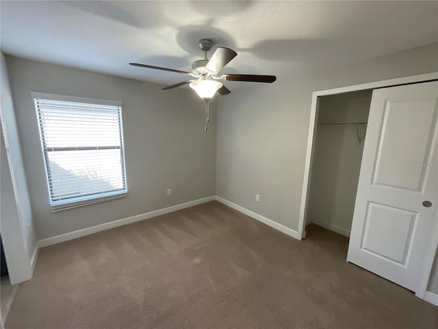 unfurnished bedroom with ceiling fan, a closet, and carpet